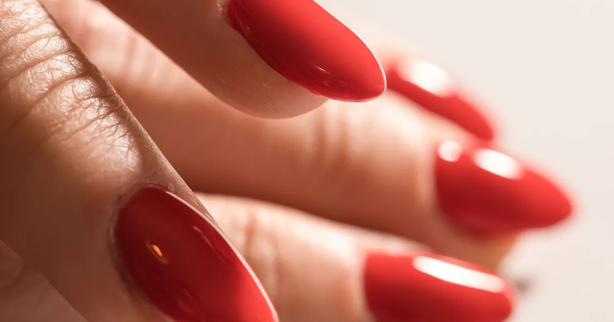 Close-up of long, glossy red almond-shaped nails